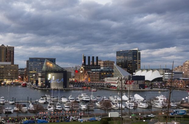 A panoramic view of Baltimore skyline with waterfront and cityscape under cloudy sky
