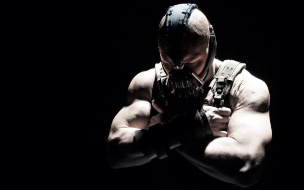 Muscular Bane standing with crossed arms wearing a mask in a dark setting