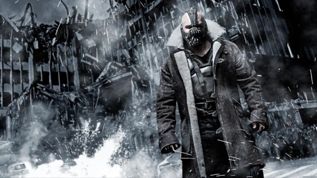 Bane character standing in a snowy war torn cityscape with a long coat and mask