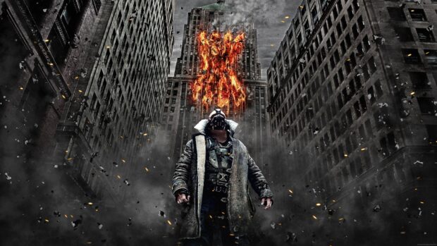 Bane character standing in the city with a fiery bat symbol burning on the building behind him