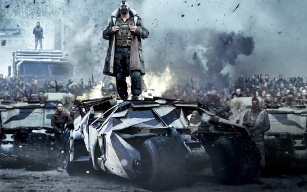 Bane standing on the Batmobile with an army behind in a dark scene