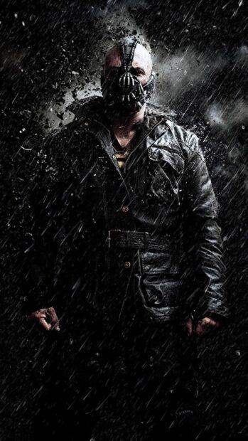 Bane stands in the rain wearing his mask and dark jacket in a powerful pose