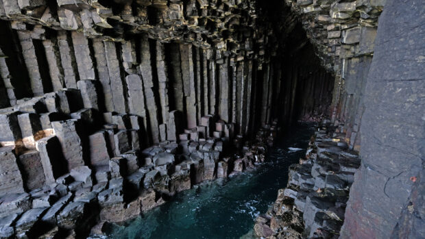 The coastal cave with vertical basalt columns and blue water in Northern Ireland is stunning, 2K PC Wallpaper