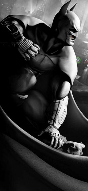 Batman Arkham City character crouching on a rooftop overlooking the city at night