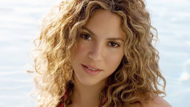 A close up of Shakira with curly hair and a soft smile near water, HD Desktop Wallpaper