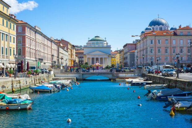The Trieste waterfront shows boats docked along colorful buildings and clear water, HD Desktop Wallpaper