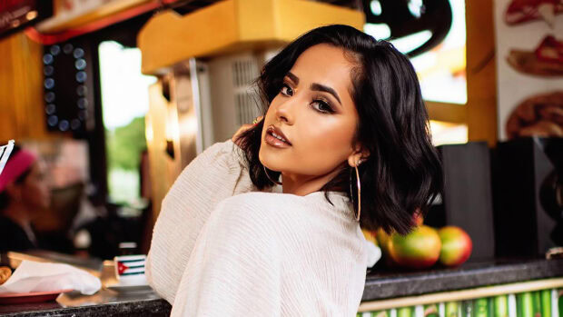 Becky G with short black hair looking over her shoulder in a casual setting