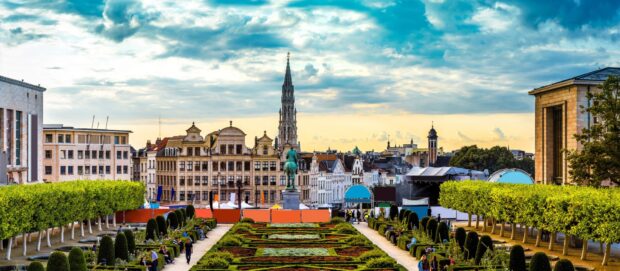 The Belgium cityscape with historical buildings and green gardens under a cloudy sky