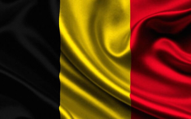 The Belgium flag with black yellow and red stripes waving smoothly on fabric texture