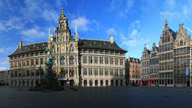 Historic Belgium architecture with statues and detailed facade under a blue sky