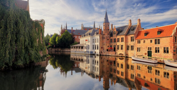 Historic Belgium town with canal and traditional buildings reflecting in the water