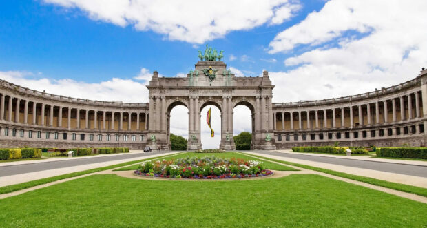 The iconic Belgium monument with a flag flying in the middle of a grand arch structure