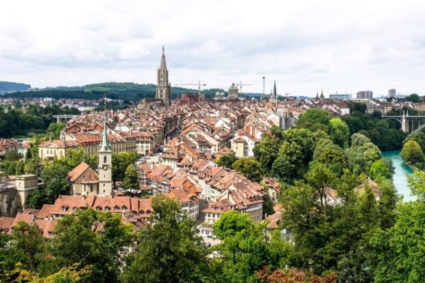 Bern Switzerland Wallpaper 2K Desktop A panoramic view of Bern Switzerland with historic buildings and lush green trees under a cloudy sky