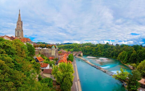 Bern Switzerland Wallpaper 2K Desktop Bern cityscape with the historic cathedral and river surrounded by green trees and buildings