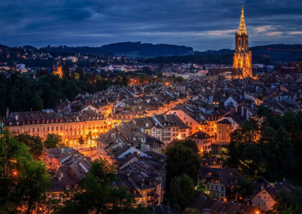 Stunning night view of Bern Switzerland cityscape with illuminated buildings and cathedral tower