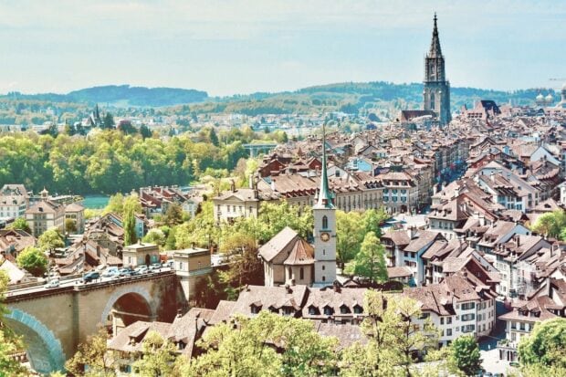 A beautiful panoramic view of Bern Switzerland with historic buildings and lush greenery