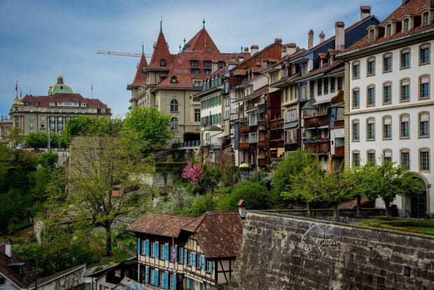 Bern Switzerland wallpaper showing historic buildings and lush greenery along the riverbank