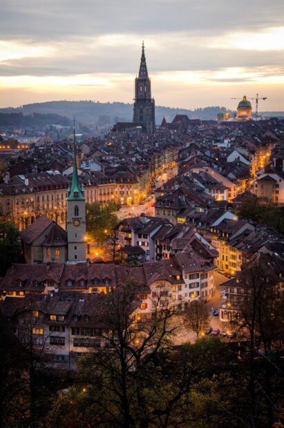 Bern cityscape at dusk with illuminated buildings and historic churches in Switzerland wallpapers