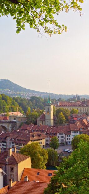 A beautiful view of Bern city Switzerland with historic buildings and green trees under a clear sky
