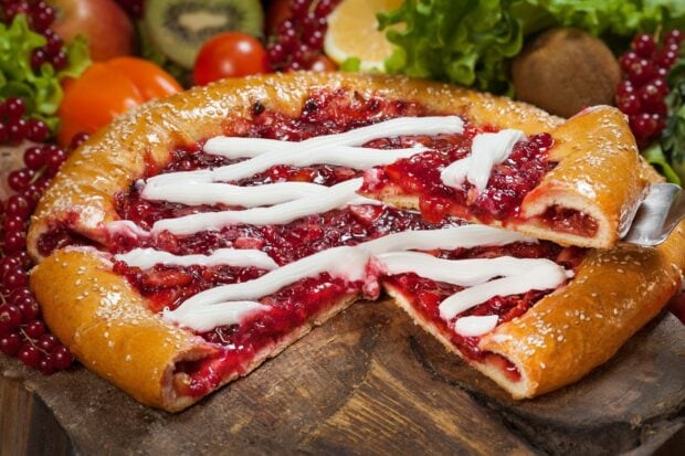 A delicious berry pie topped with cream drizzle surrounded by fresh fruits and greens, HD Desktop Wallpaper