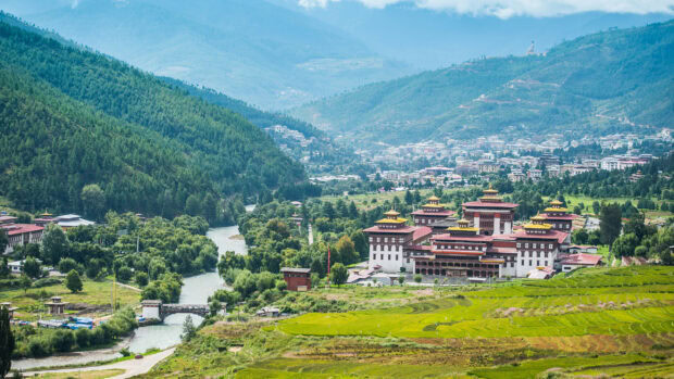 Traditional Bhutanese architecture surrounded by mountains and lush greenery in Bhutan valley