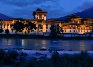 Traditional Bhutanese architecture by the river at dusk in Bhutan
