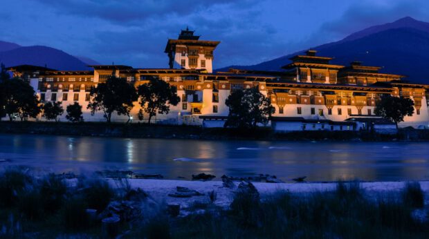 Traditional Bhutanese architecture by the river at dusk in Bhutan