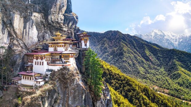 Tiger's Nest Monastery built into the cliffs of Bhutan with lush green mountains in the background