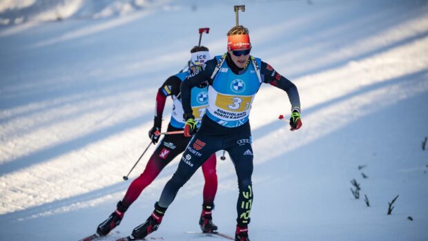 Biathlon athlete skiing on snow during a competition wearing race bib number 3
