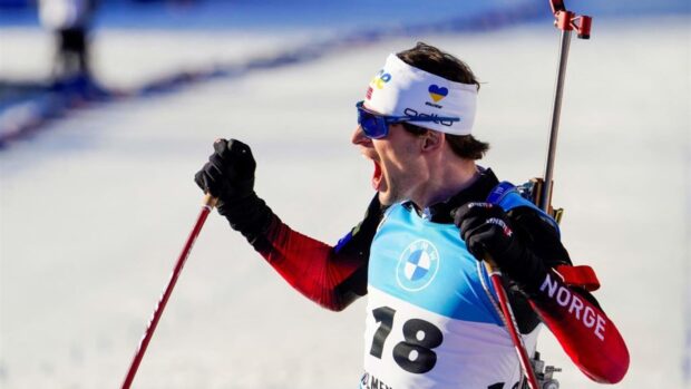 Male athlete wearing Norway uniform celebrating victory in biathlon competition