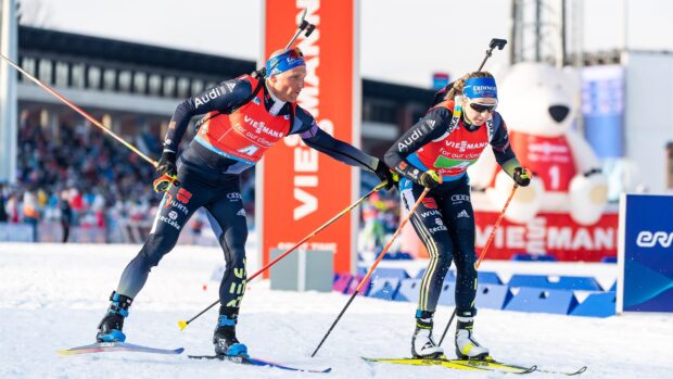 Two biathlon athletes skiing during a competitive event on snow in cold weather conditions
