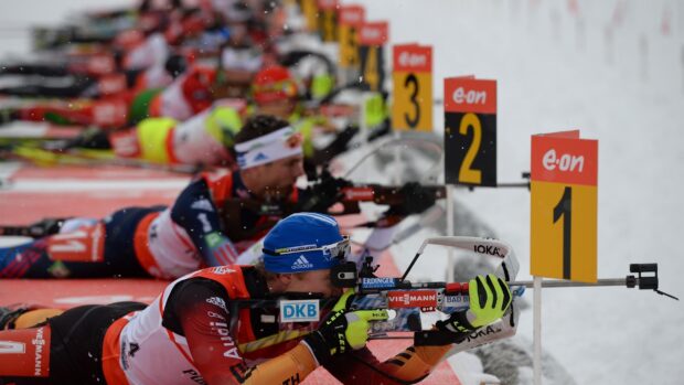 Biathlon athlete aiming a rifle during a winter competition shooting stage