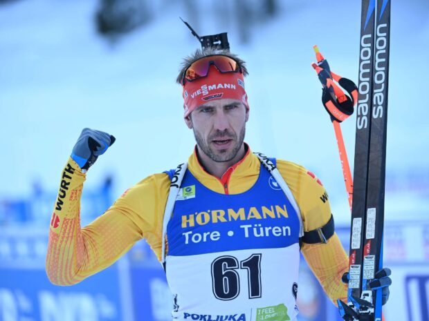 Male athlete competing in biathlon with skis and rifle showcasing biathlon sport