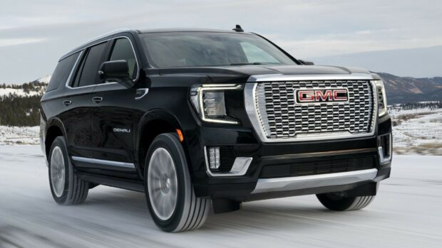 A black GMC Denali is driving on a snow covered road in a mountainous area, HD Desktop Wallpaper