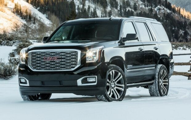A black GMC SUV drives through the snow with mountains in the background in this GMC wallpapers, HD Desktop Wallpaper