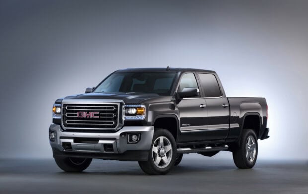 A black GMC truck is displayed in a studio with bright lighting, 2K Desktop Wallpaper