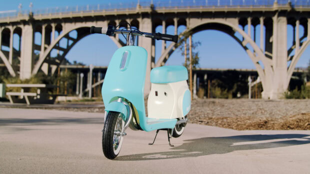 A blue vintage scooter is parked near a bridge under clear blue sky in the city, 4K Desktop Wallpaper