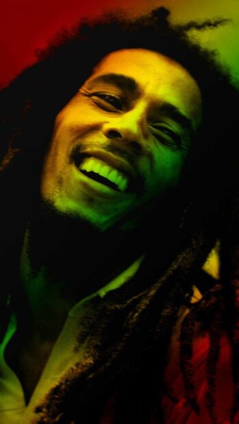 A cheerful man with dreadlocks smiling brightly under colorful lighting, HD Mobile Wallpaper