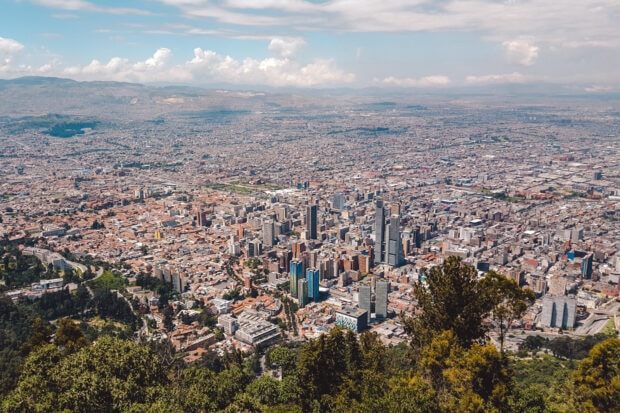 The Bogota city skyline extends towards the horizon under a cloudy sky, HD Desktop Wallpaper