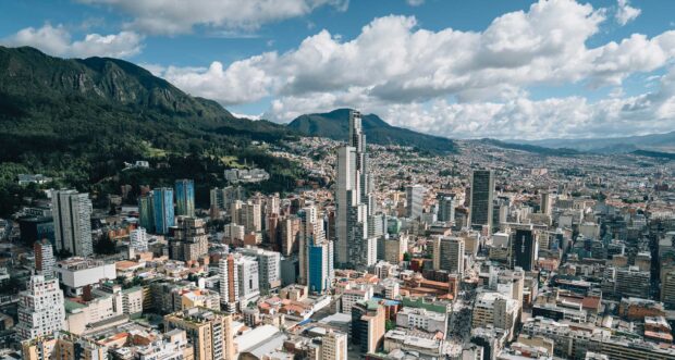 The Bogota city skyline is shown with tall buildings and mountains in the background, HD Desktop Wallpaper