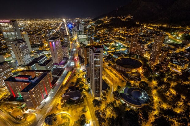 The Bogota cityscape at night shows illuminated streets and tall buildings, 2K Desktop Wallpaper