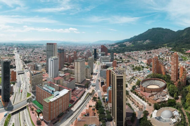 A vibrant cityscape of Bogota showcases an array of tall buildings and a clear sky, HD Desktop Wallpaper