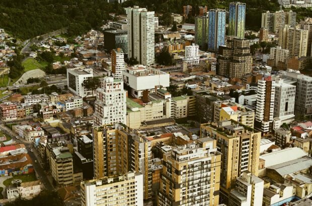 An aerial view of the city showing urban buildings in Bogota with green areas, 2K Desktop Wallpaper