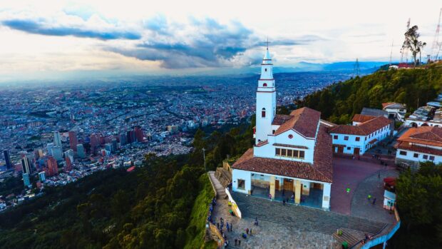 A scenic view of Bogota with a prominent hilltop church and expansive city below, 2K Desktop Wallpaper