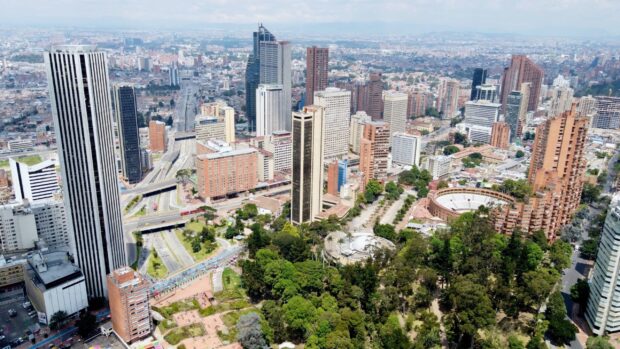 Aerial view of Bogota cityscape showing tall buildings and green spaces in the urban area, 2K Desktop Wallpaper