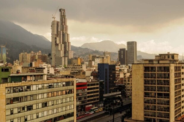 A view of Bogota shows tall skyscrapers and mountains in the distance, HD Desktop Wallpaper