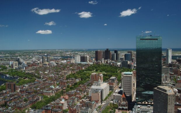 Aerial view of Boston cityscape with clear blue sky and city buildings in sunlight