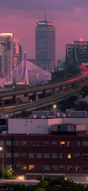 Iconic Boston buildings and Zakim Bridge illuminated at dusk in the cityscape of Boston