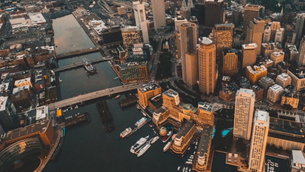 Aerial view of Boston cityscape with river and tall buildings at sunset