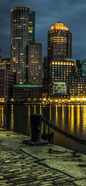 Night view of Boston city skyline with illuminated buildings and waterfront